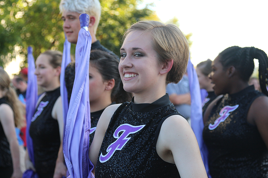 FHS Color Guard student participating in the annual Homecomming Parade on the Fayetteville Square. Student in black FHS uniform with purple flag.