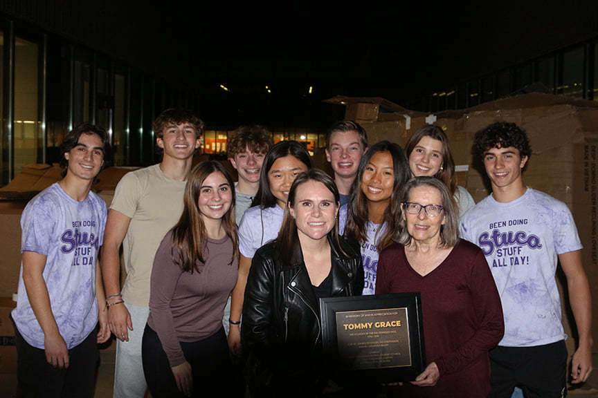 Participants in the FHS Annual Homeless Vigil pose for a picture while honoring the founder of the homeless vigil, Tommy Grace, with a plaque.