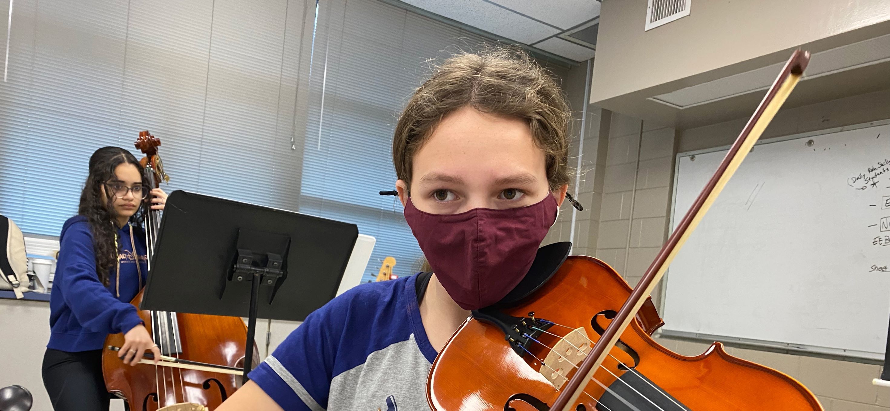student playing violin in orchestra class